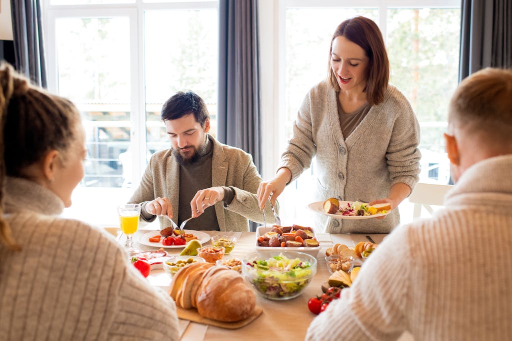 Warm indoor gathering with family enjoying a meal together, showcasing joy and togetherness.