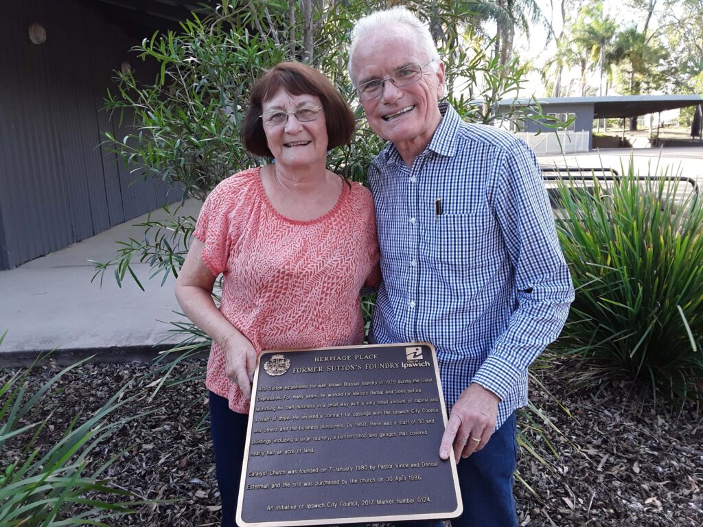 Vince and Denise Esterman behind Ipswich City plaque at Catalyst Church
