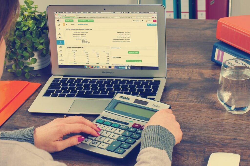 woman using calculator in bookkeeping
