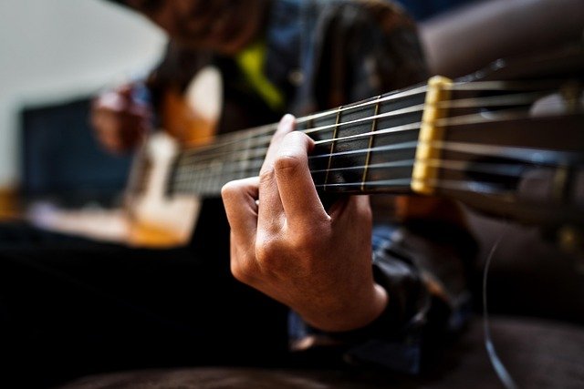 Young man learning to play guitar