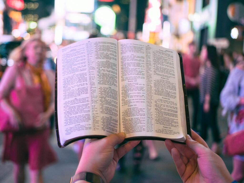 Man holding open Bible in front of congregation